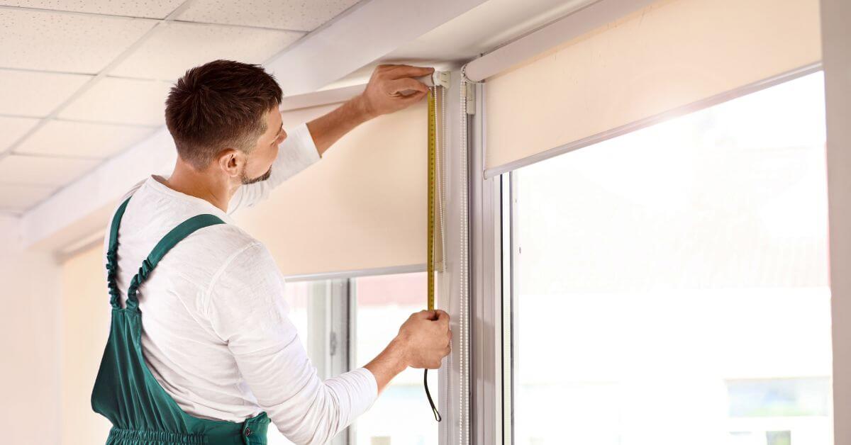 Professional installer mounting custom window blinds in a Phoenix Valley home